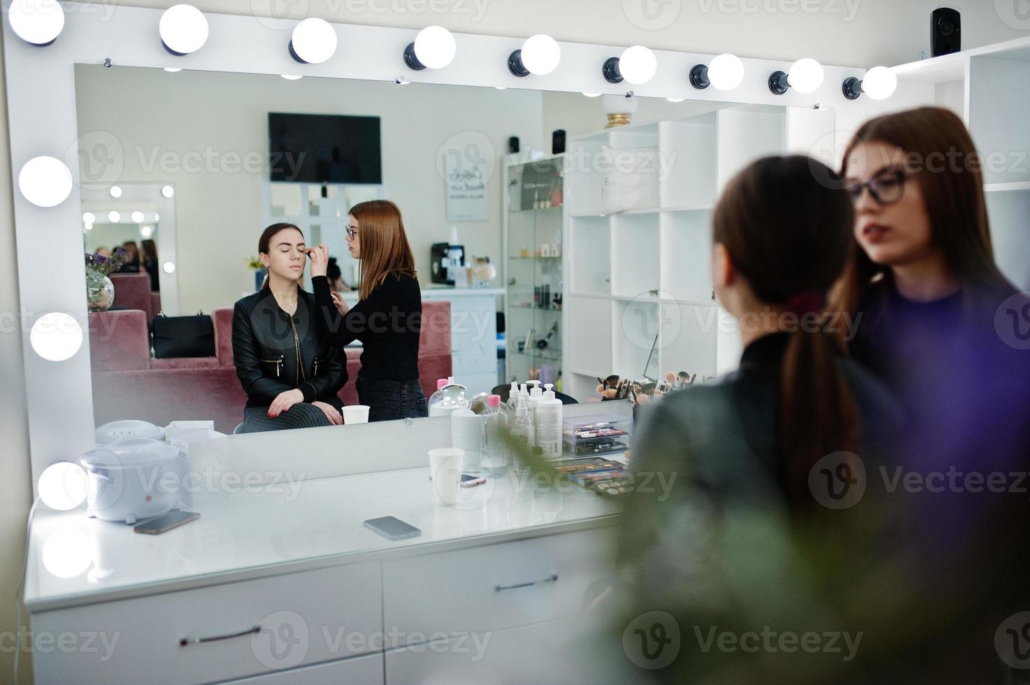 make-up artiest werk in haar beauty visage studio salon. vrouw solliciteert door professionele make-up master. schoonheidsclubconcept. foto