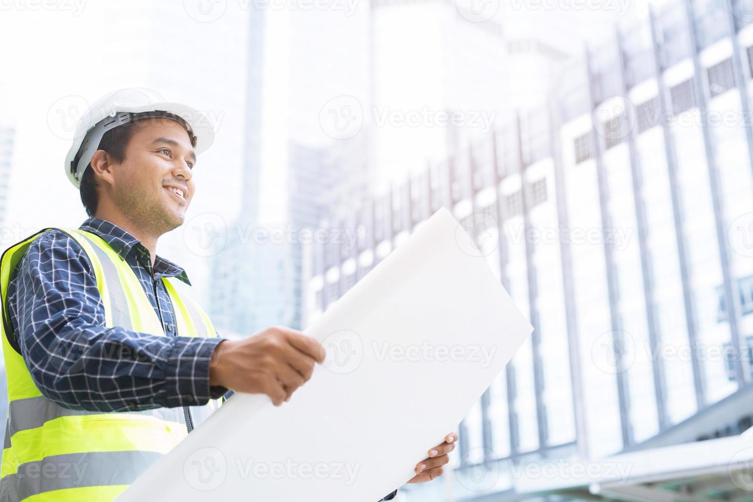 portret van technische aziatische man bouwvakker met rolpapier van tekening structureel plan veiligheid witte helm en draag reflecterende kleding voor de veiligheid van het werk. foto