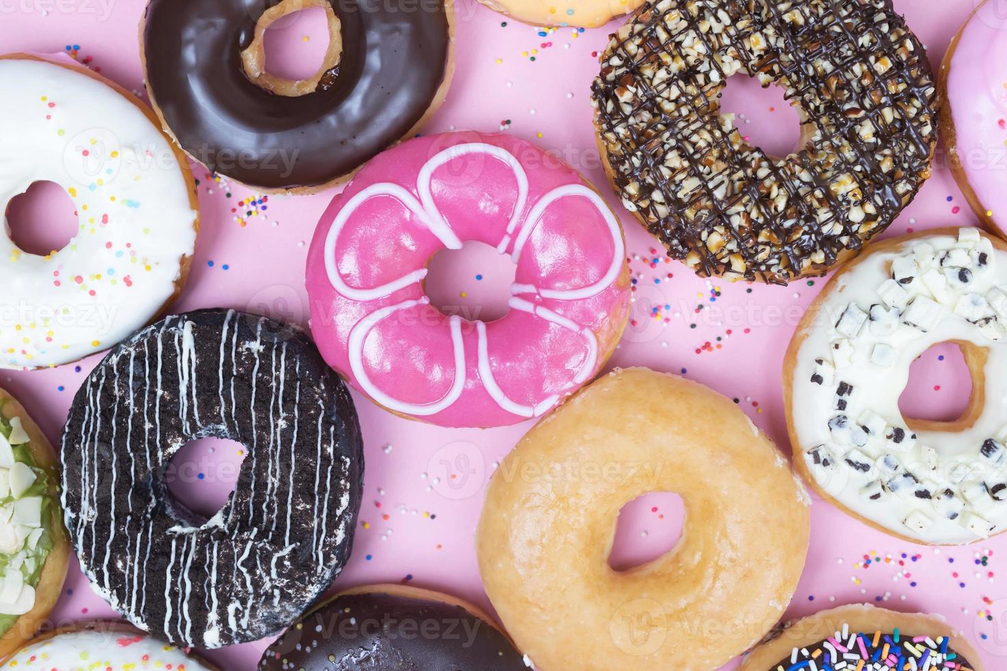 geassorteerde donuts met chocolade glazuur, topping hagelslag donuts kleurrijke variëteit en verscheidenheid aan smaken mix van multi gekleurde zoete donuts met frosted bestrooid op blauwe achtergrond. foto