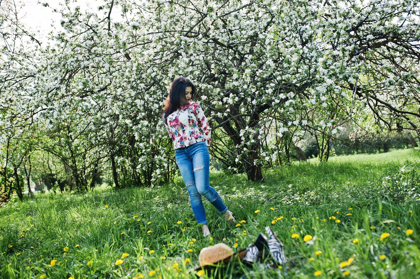 lente portret van brunette meisje in roze bril en hoed op groene bloesem tuin. foto