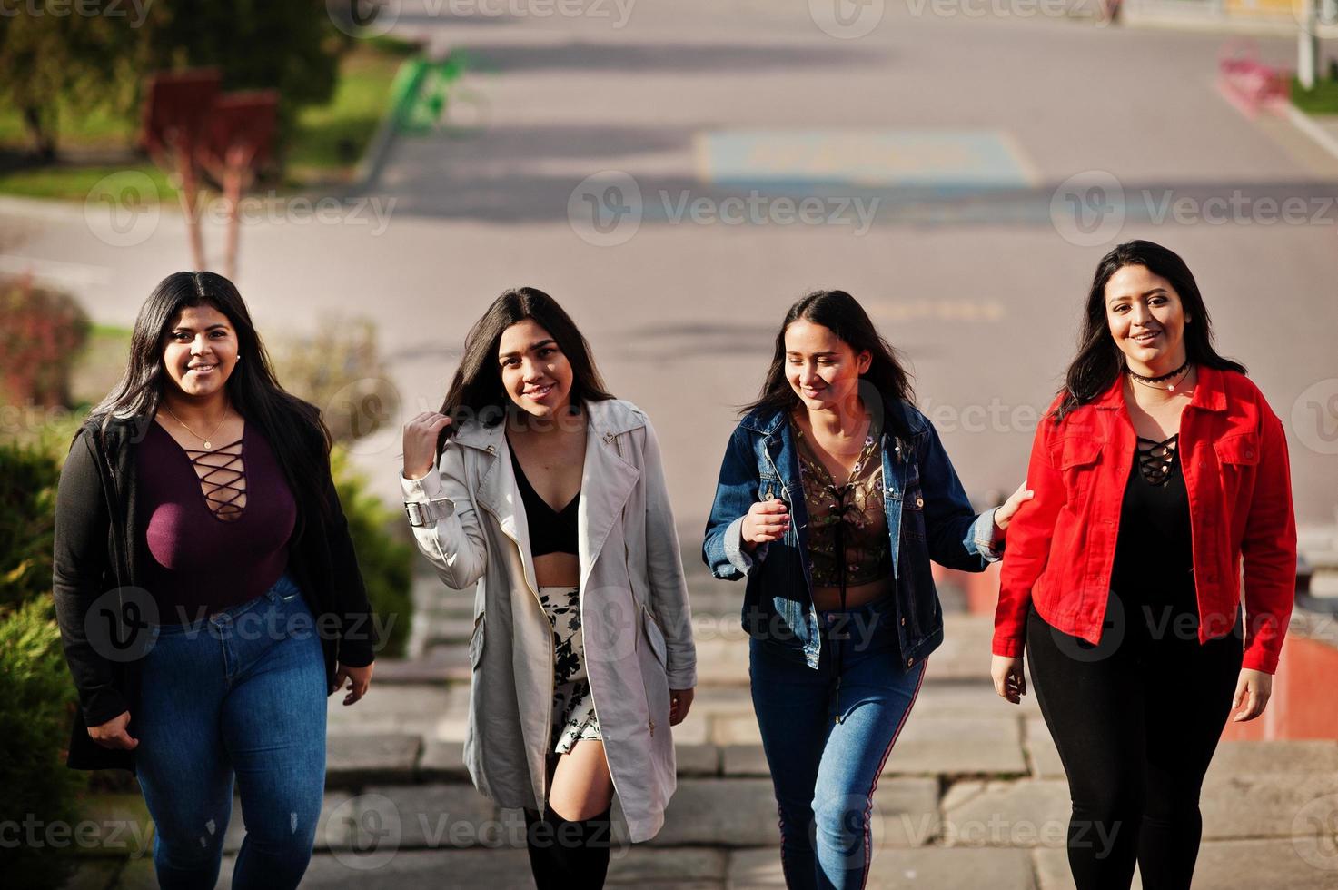 groep van vier gelukkige en mooie latino-meisjes uit ecuador poseerden op straat. foto