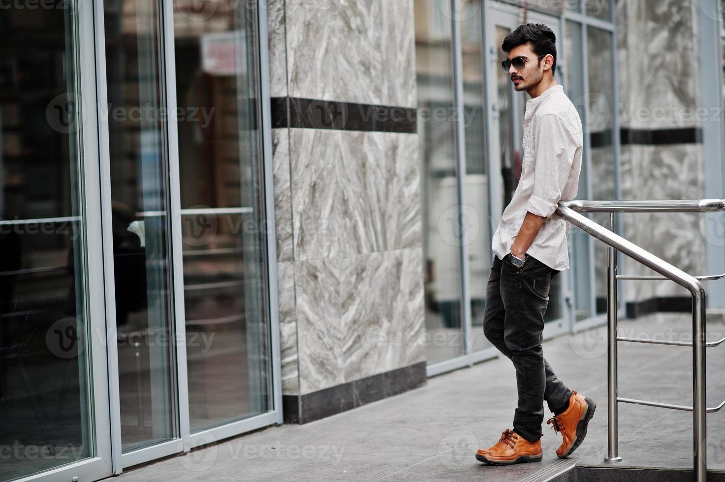 stijlvolle Indiase model man in casual kleding en zonnebril poseerde buiten op straat van india. foto