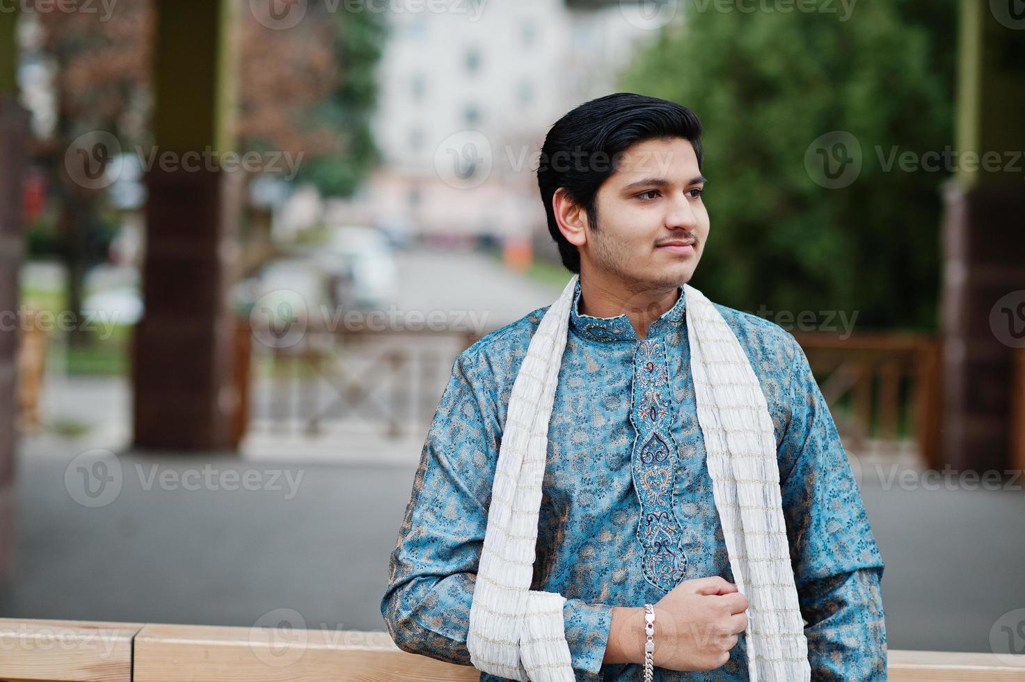 indiase man draagt traditionele kleding met witte sjaal buiten geposeerd. foto