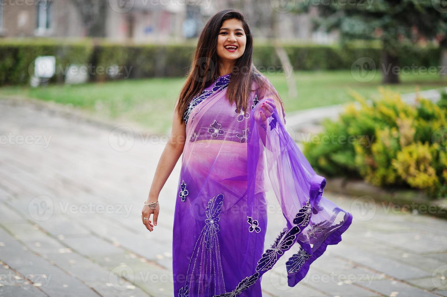 indiase hindoe meisje op traditionele violet saree poseerde op herfst straat. foto