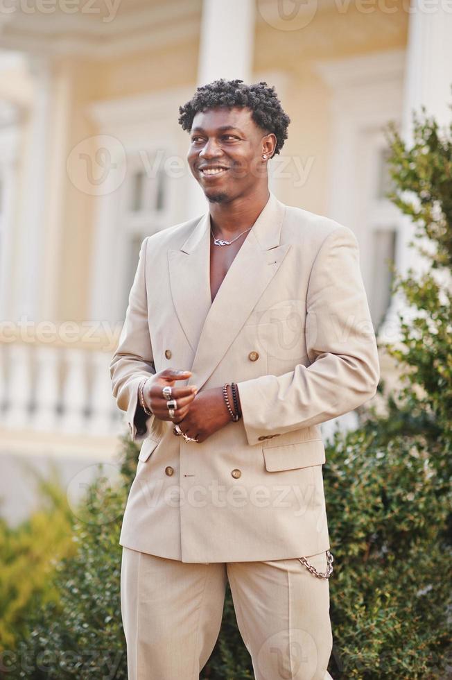 stijlvolle afro man in beige old school pak. modieuze jonge Afrikaanse man in casual jas op blote torso. foto