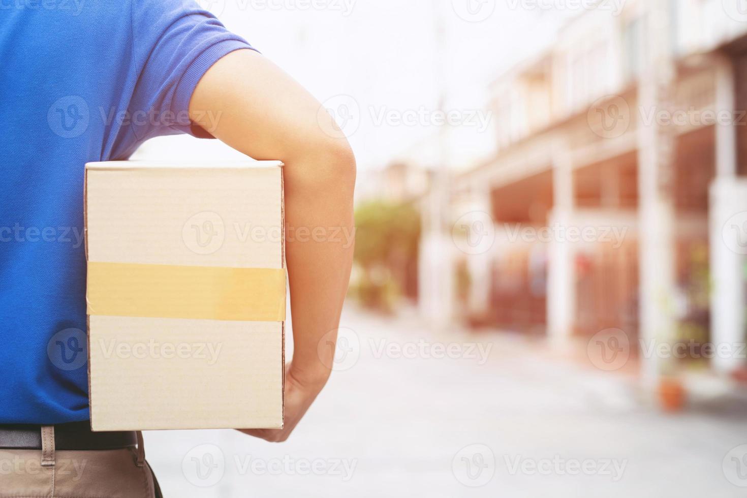 pakketbezorger van een pakket via een dienst naar huis sturen. verzend hand indiening klant die een levering van dozen van bezorger accepteert. foto