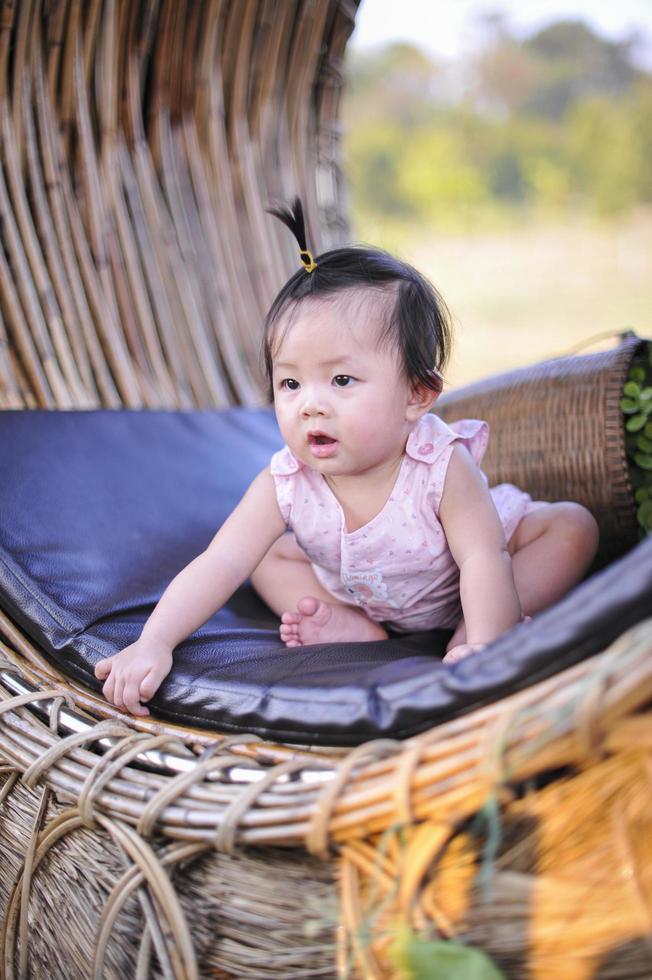 portret schattig baby kind peuter zittend in roze jurk, close-up Aziatische babymeisje met geluk van 8 maanden oud foto