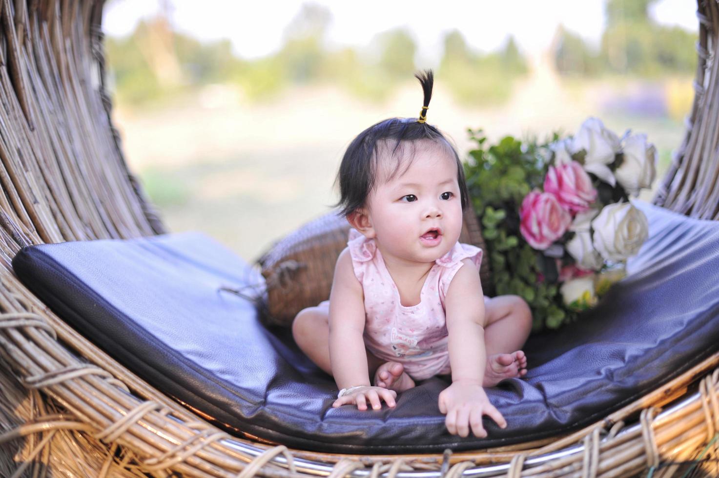 klein kind meisje zit met geluk van 8 maanden oud, portret schattig babymeisje Azië van 8 maanden oud foto