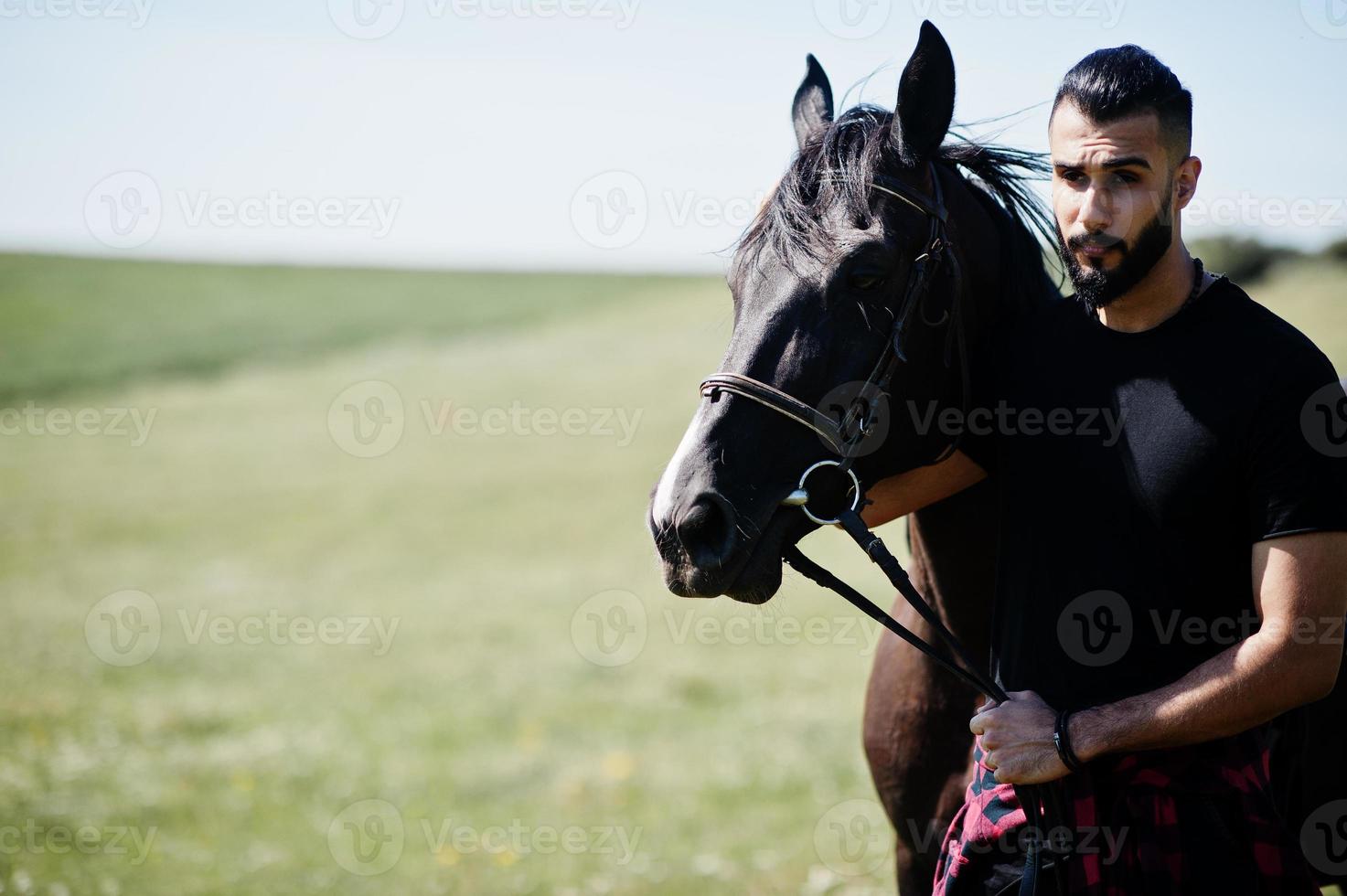 Arabische lange baard man slijtage in het zwart met Arabisch paard. foto