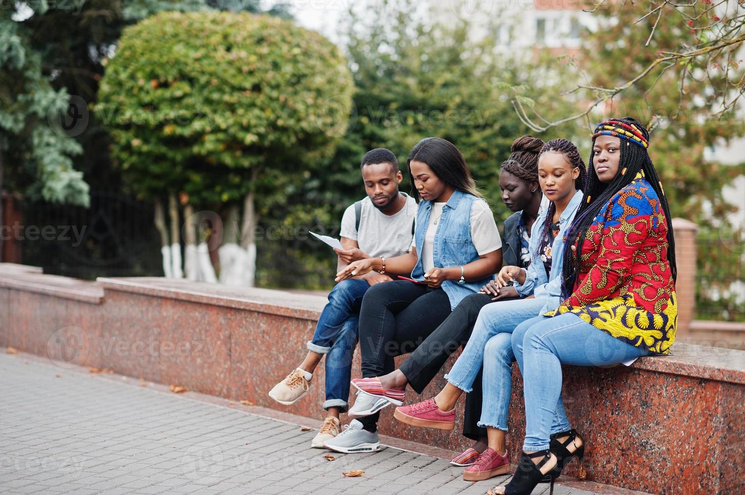 groep van vijf afrikaanse studenten die samen tijd doorbrengen op de campus op de universiteitswerf. zwarte afro-vrienden studeren. onderwijs thema. foto