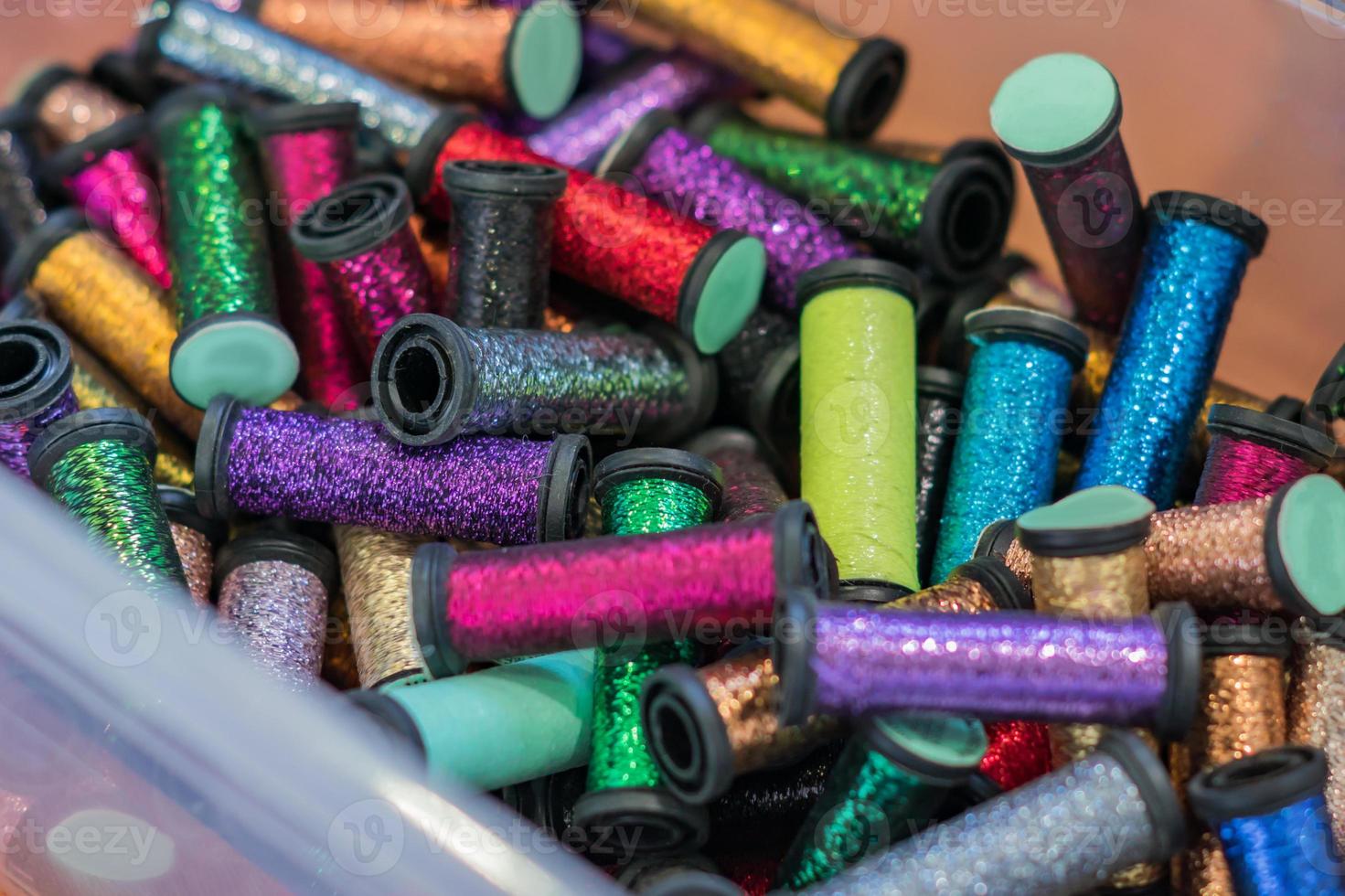 rollen met metalen draden in plastic container in assortiment voor handwerk foto