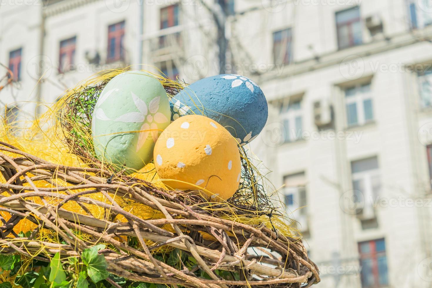 houten nest met drie veelkleurige eieren. Pasen decoratie buiten geschilderd foto