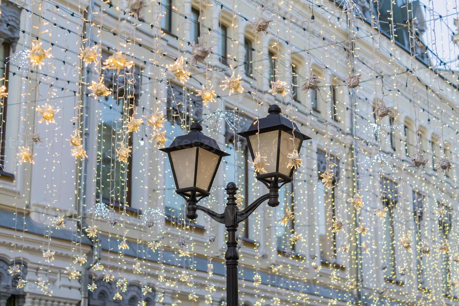 straat kerstversiering. witte slingers boven de straat foto