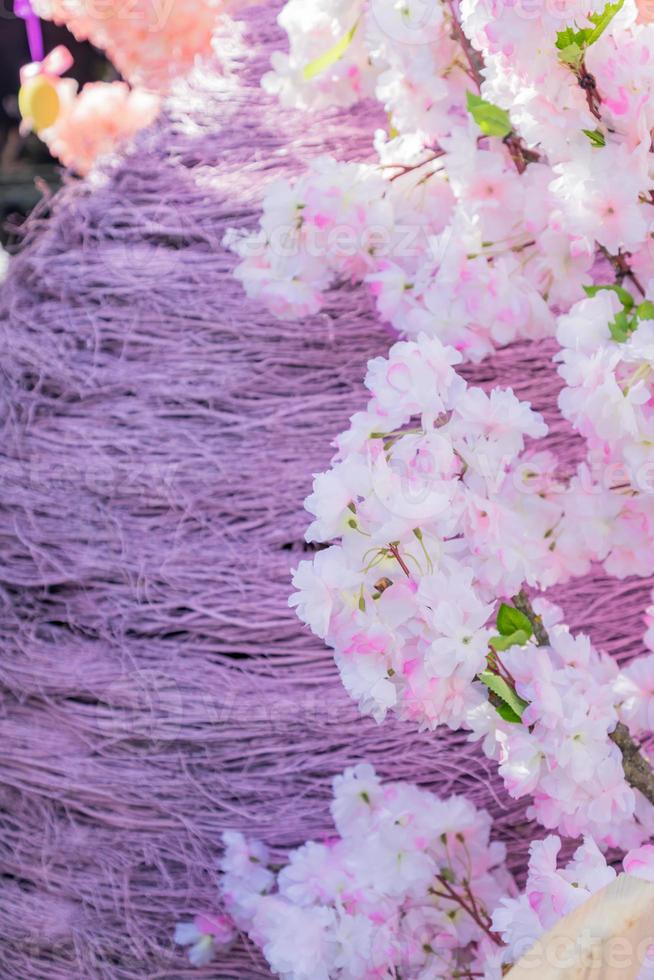 rieten paasei en kunstmatige bloeiende appelboom. kleurrijke achtergrond foto