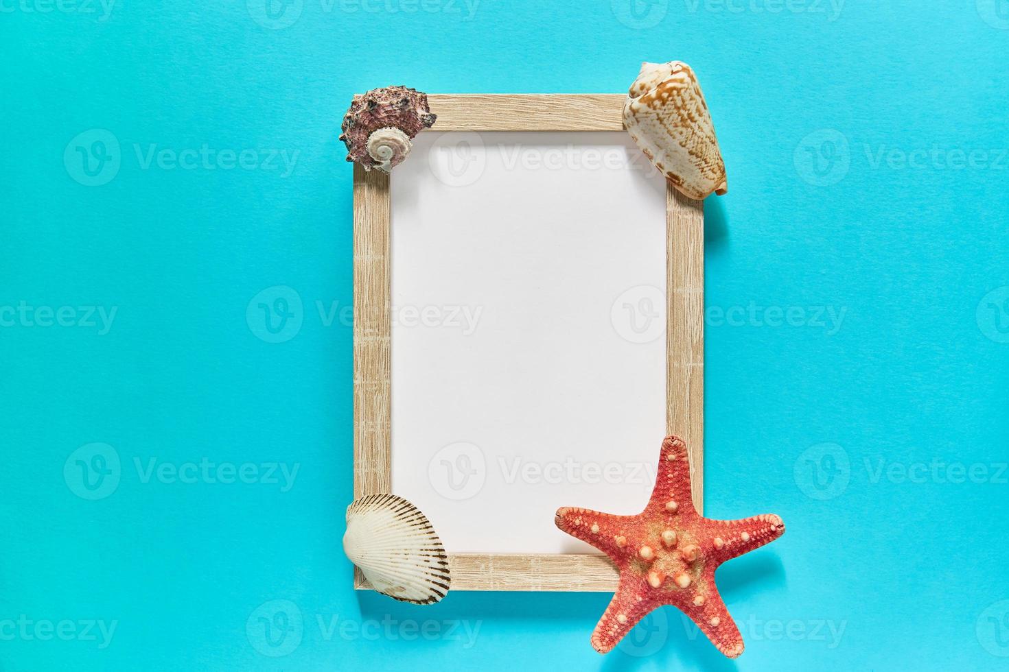 mockup fotolijstje met zeeschelpen en zeesterren op blauwe achtergrond. marien decoratieconcept foto