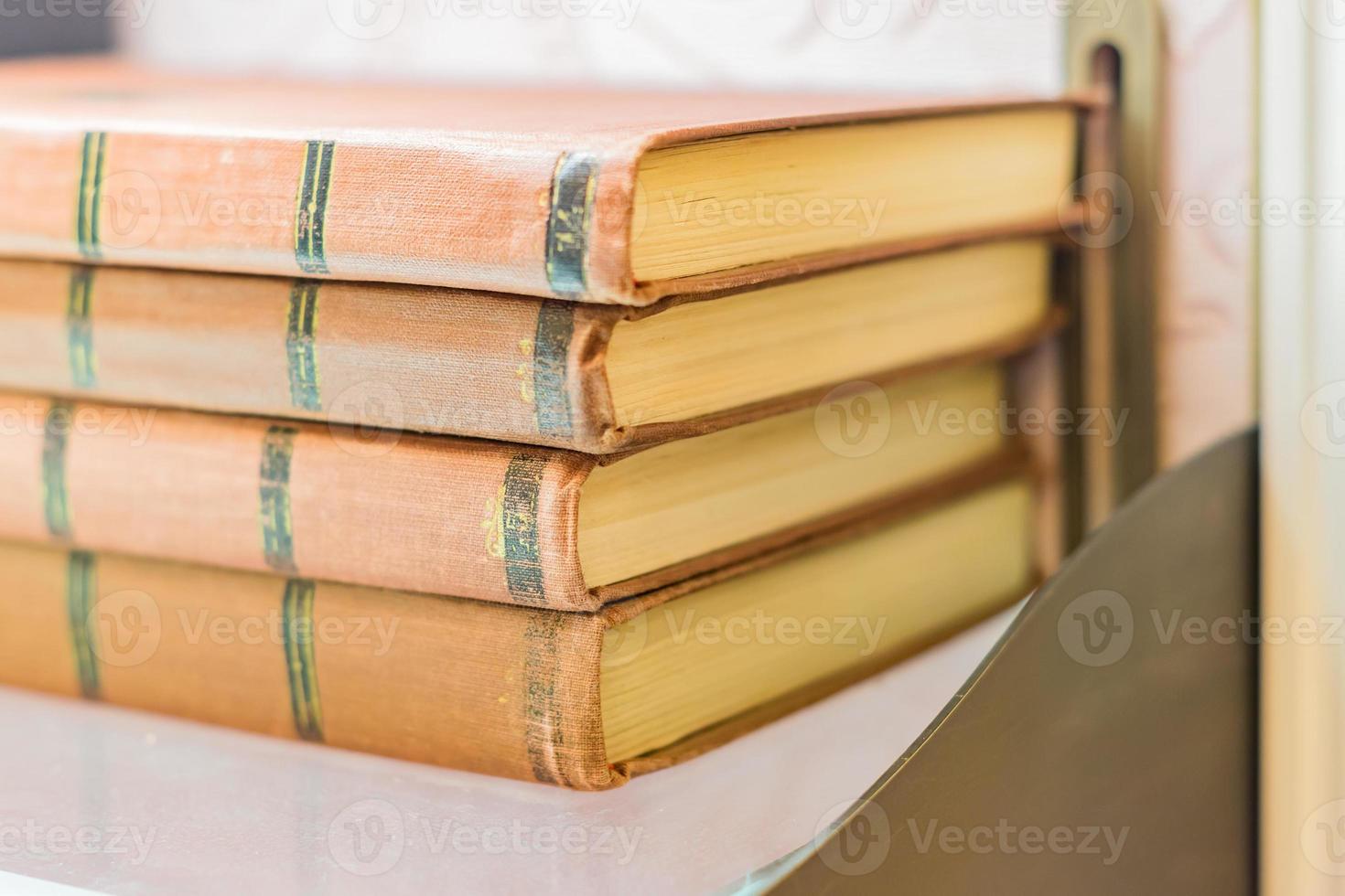 stapel oude boeken met bruine retro omslag op plank. selectieve focus foto