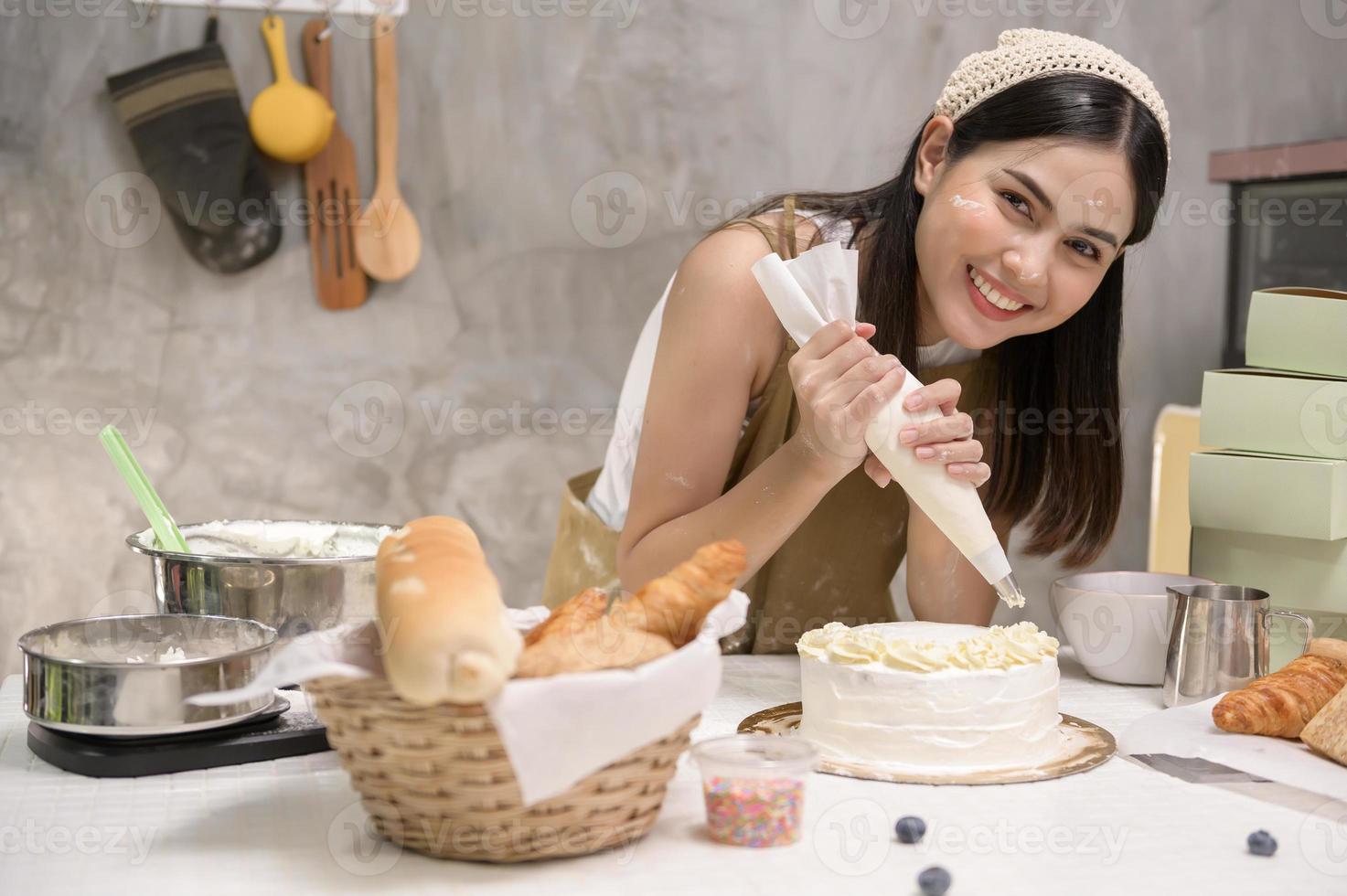 jonge mooie vrouw bakt in haar keuken, bakkerij en coffeeshopbedrijf foto