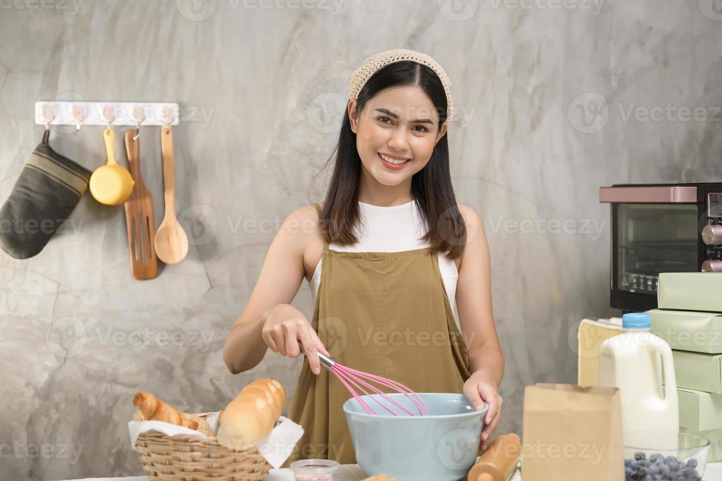 jonge mooie vrouw bakt in haar keuken, bakkerij en coffeeshopbedrijf foto