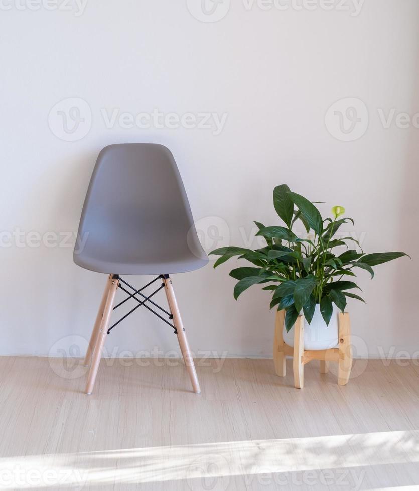 grijze stoelen en groene planten op de houten vloer in een minimale kamer. foto