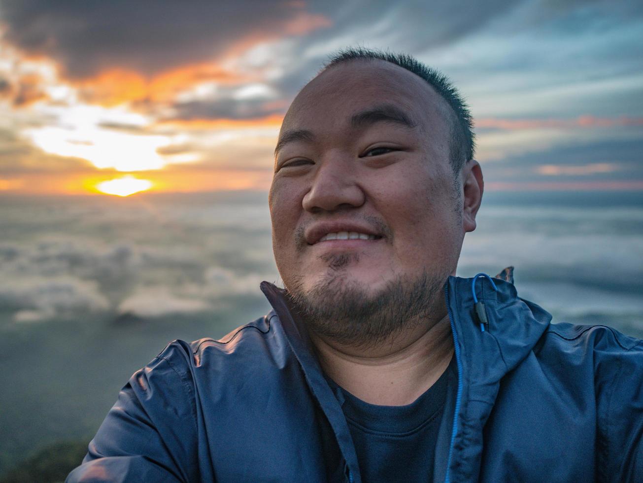 Aziatisch reiziger nemen een selfie met mooi zonsopkomst lucht Aan de berg foto