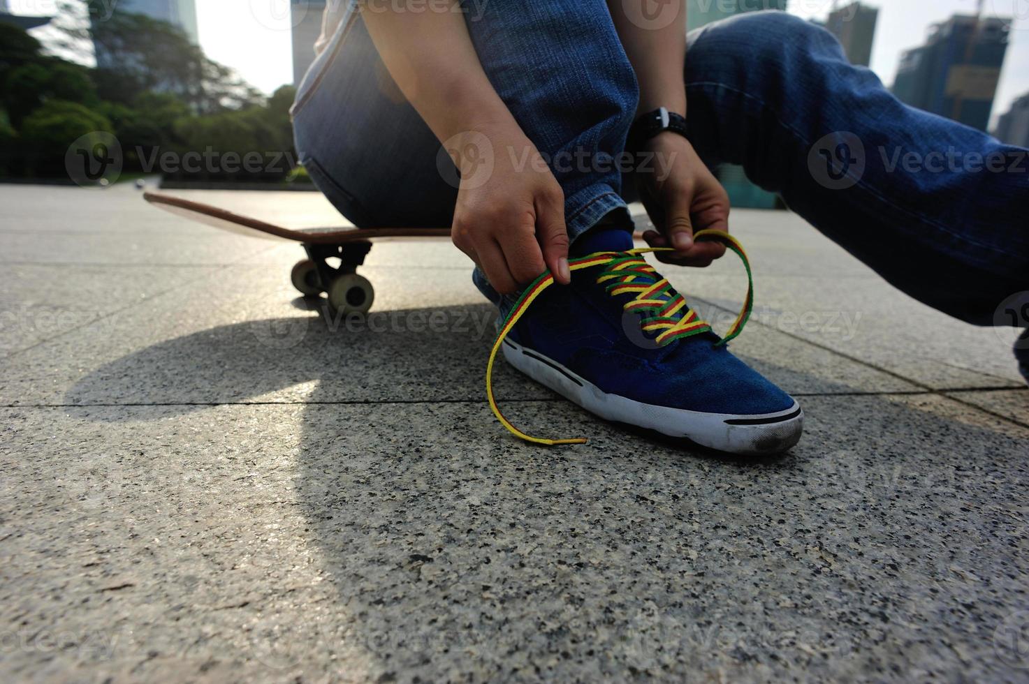 skateboarder koppelverkoop schoenveter op skatepark foto