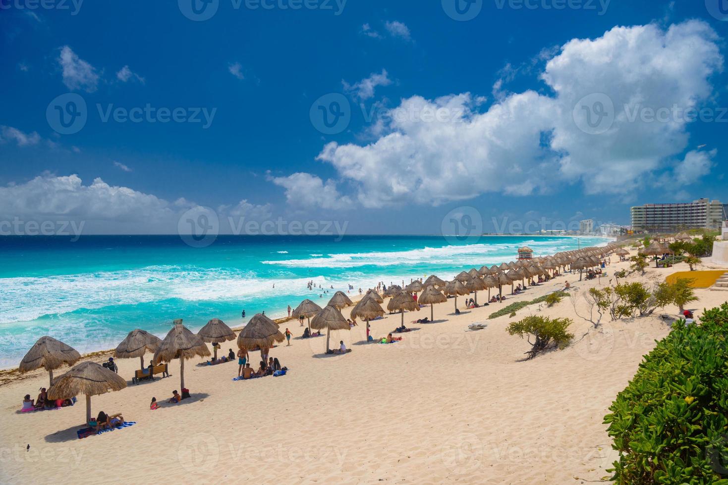 paraplu's op een zandstrand met azuurblauw water op een zonnige dag in de buurt van cancun, mexico foto