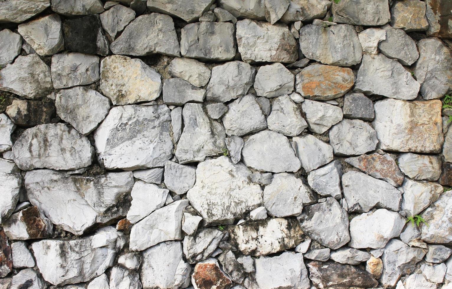 ruw rots steen structuur in de muur welke is oud, grunge en vuil foto