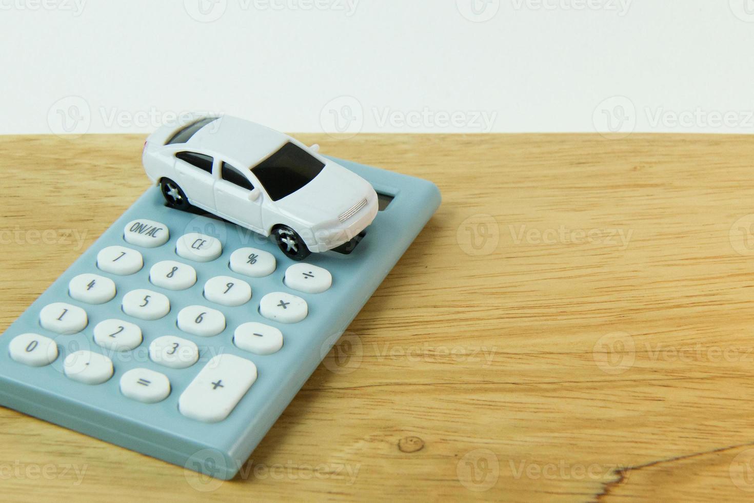 witte auto speelgoed en blauwe rekenmachine witte achtergrond. foto