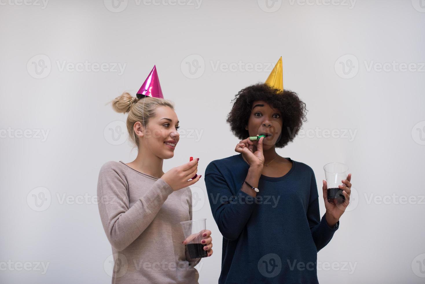 glimlachen Dames in partij petten blazen naar fluitjes foto