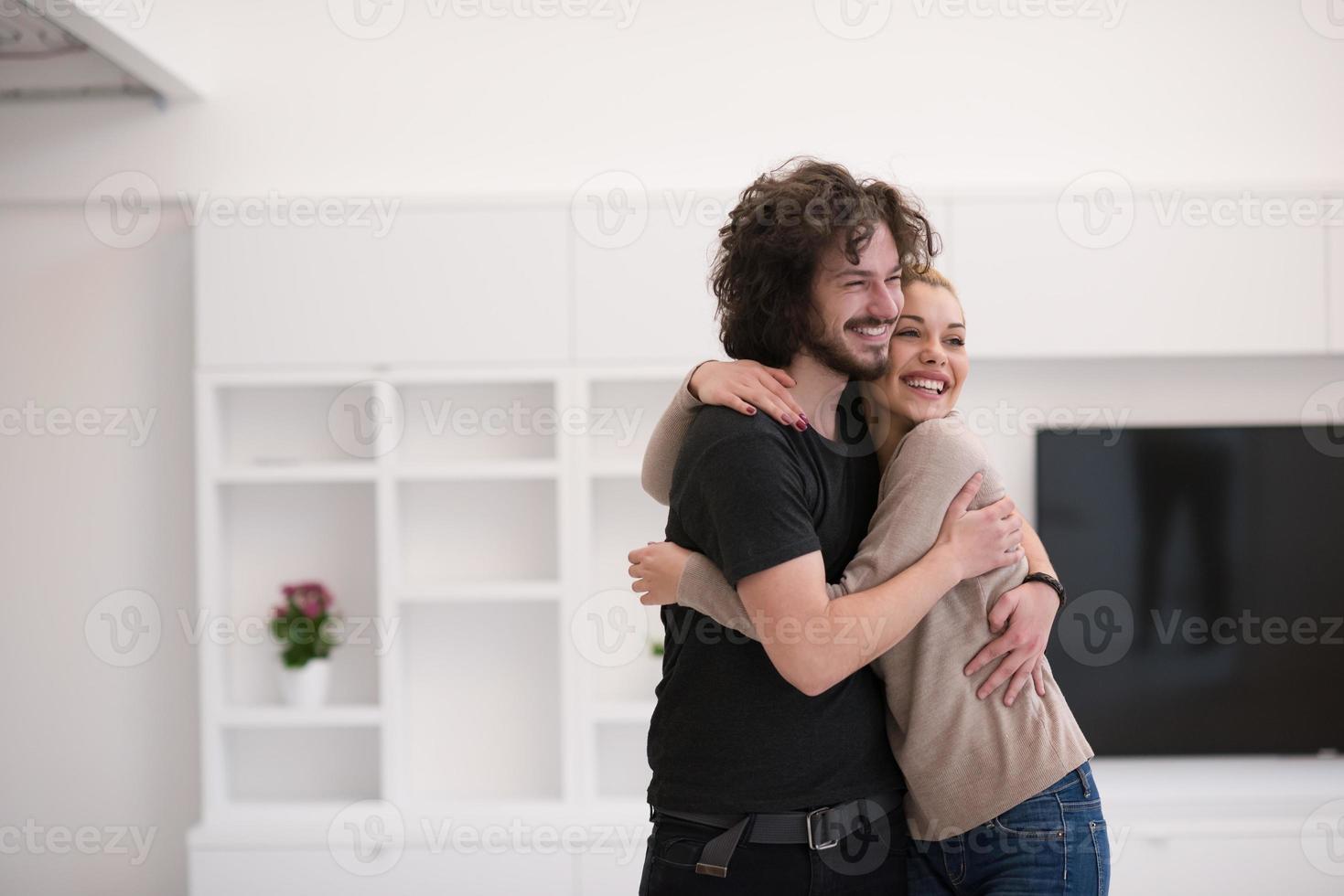 paar knuffelen in hun nieuwe huis foto