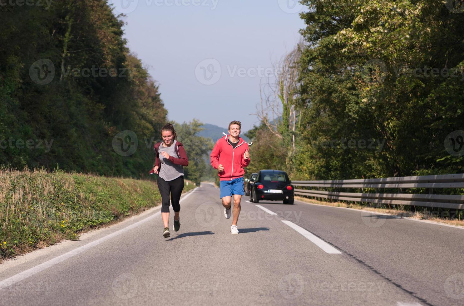 jong stel joggen langs een landweg foto