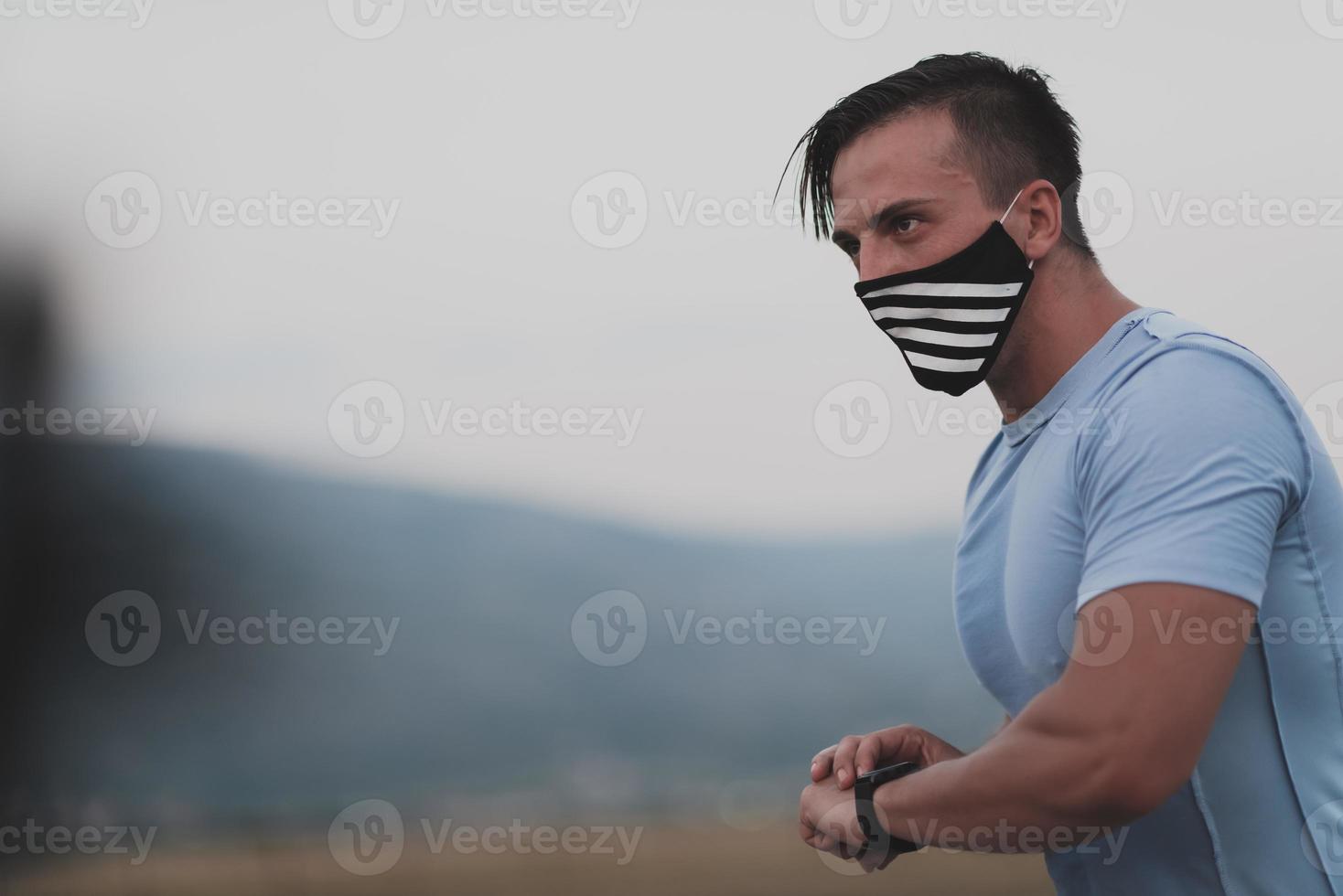 geschiktheid Mens in nat sportief kleren vervelend zwart beschermend gezicht masker rennen buitenshuis in de stad gedurende coronavirus uitbraak. covid 19 en fysiek jogging werkzaamheid sport en geschiktheid. nieuw normaal foto