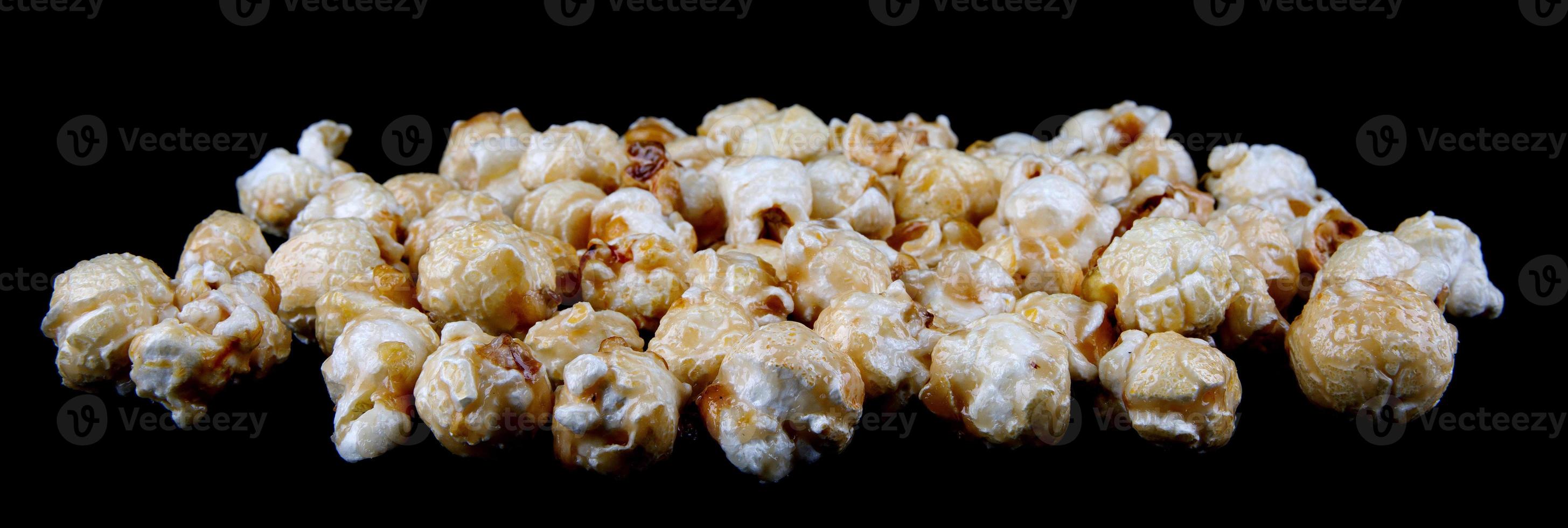 krokant popcorn is geïsoleerd Aan een zwart achtergrond. popcorn in karamel glazuur. foto