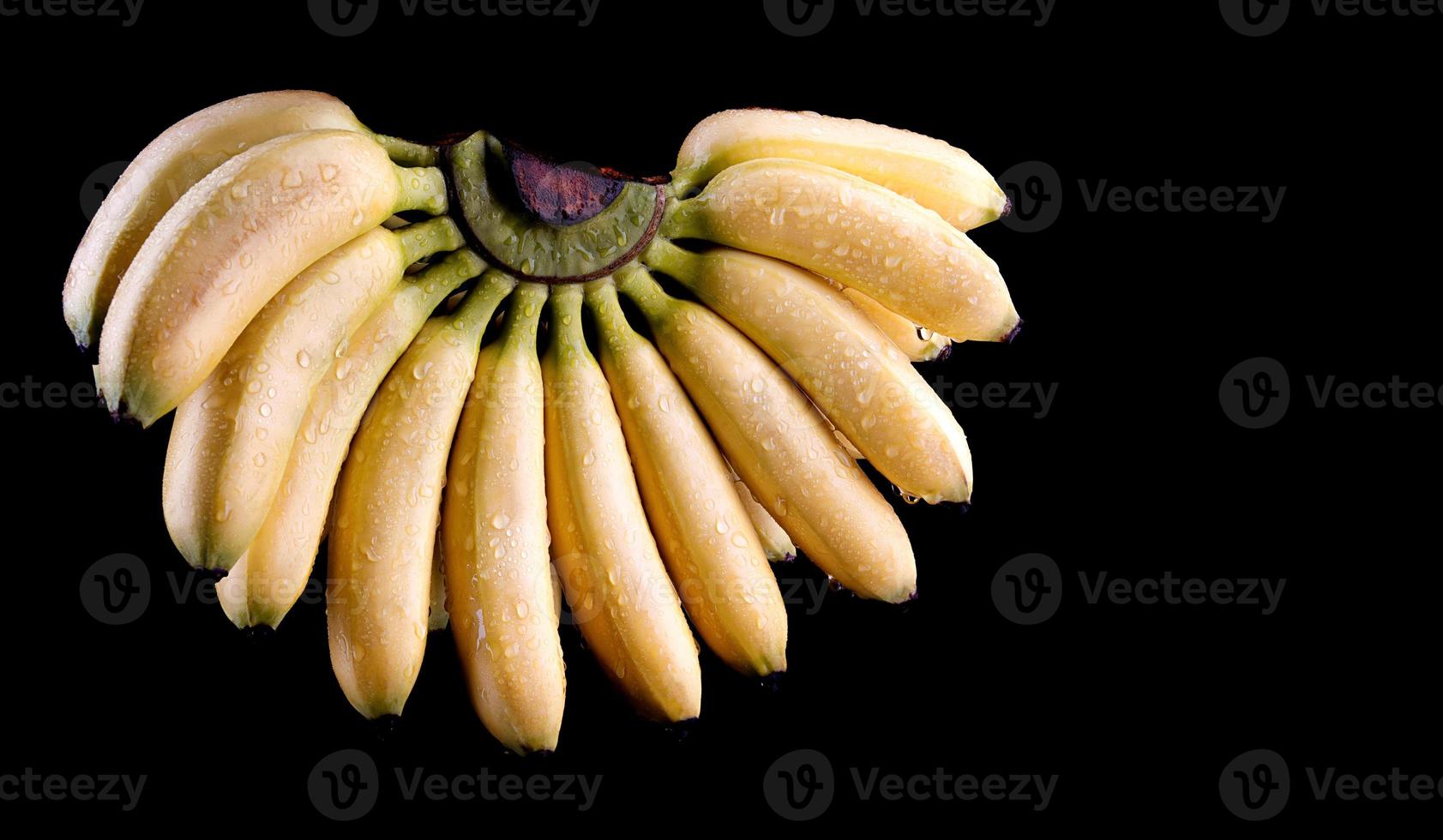 een mooie tros bananen is geïsoleerd op een zwarte achtergrond. foto