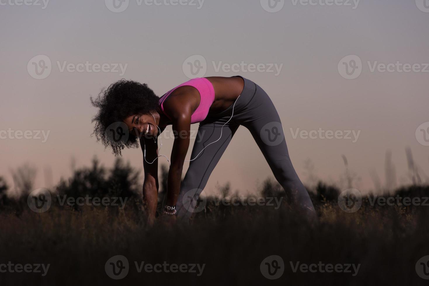 zwart vrouw is aan het doen uitrekken oefening ontspannende en warm omhoog foto