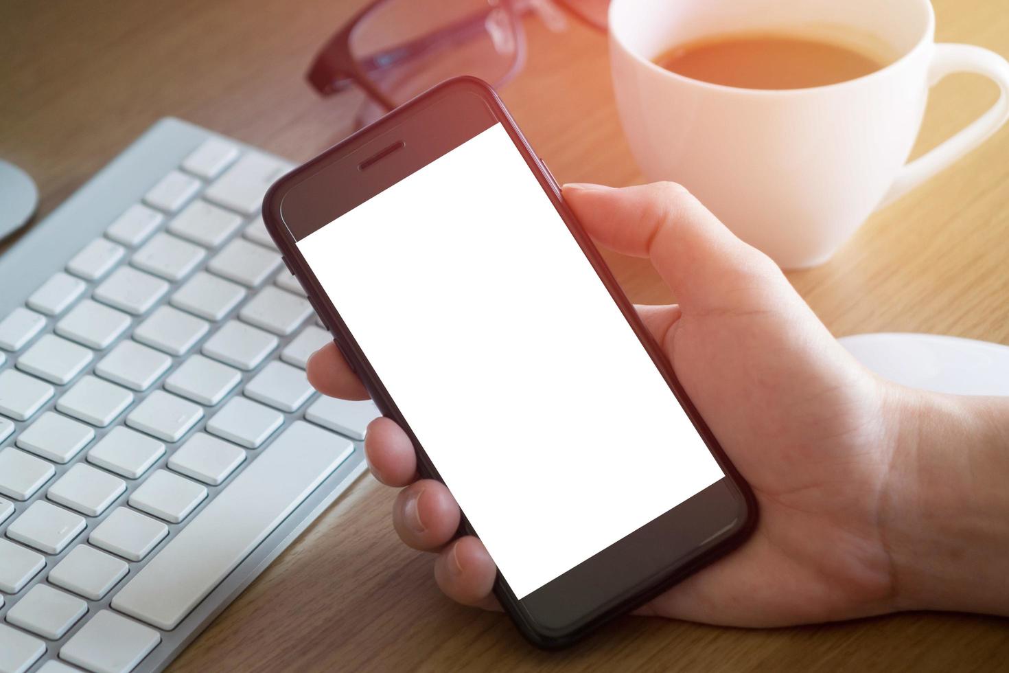 vrouw handen Holding leeg scherm van smartphone Aan hout bureau werk foto