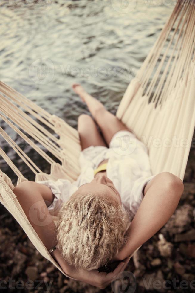 blond vrouw resting Aan hangmat foto