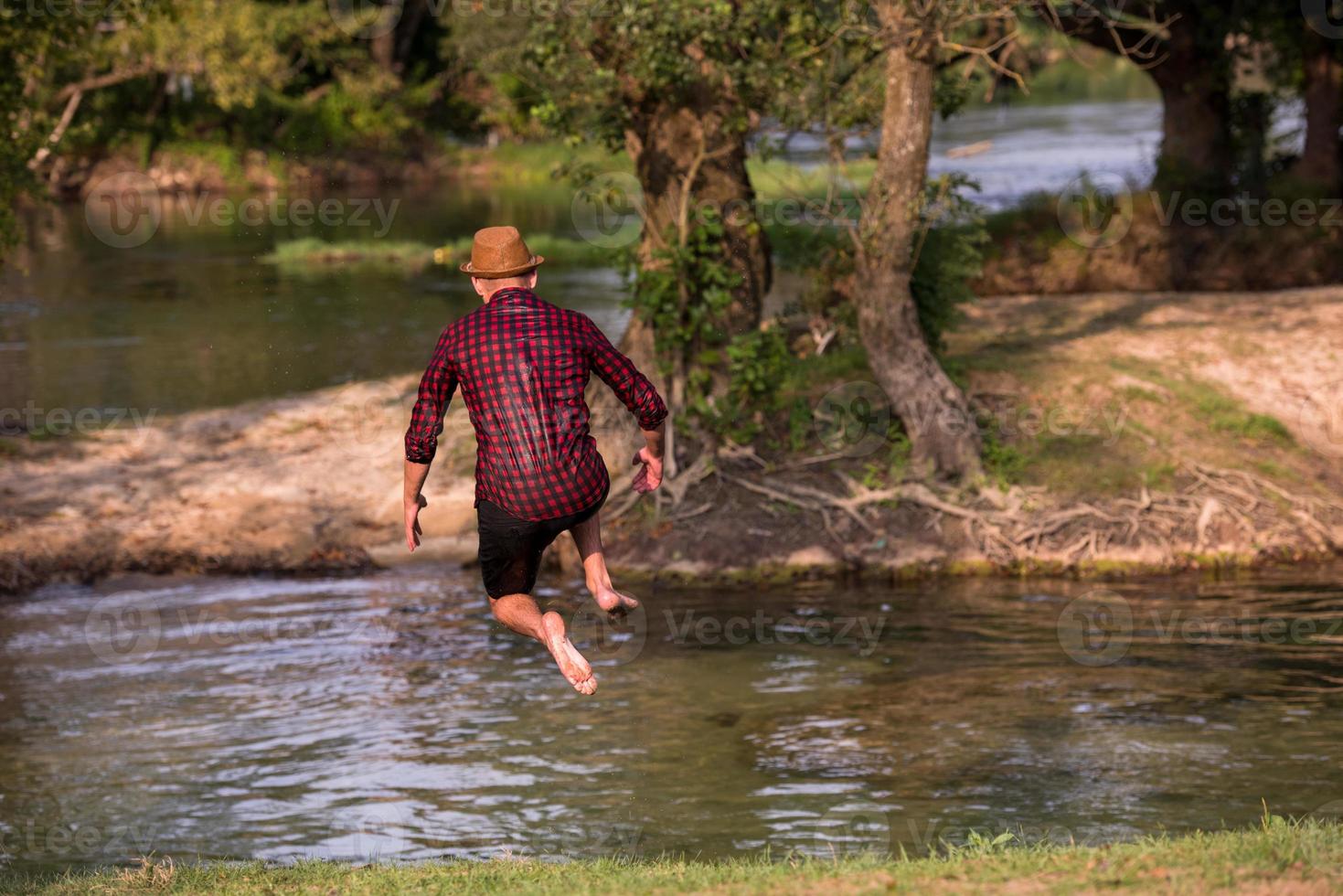 Mens jumping in de rivier- foto