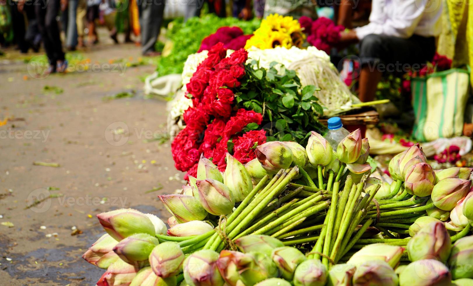 lotus en rood roos zijn gehouden in een rij voor verkoop in hoera bloem markt, kolkata bloem markt, mullik ghat foto