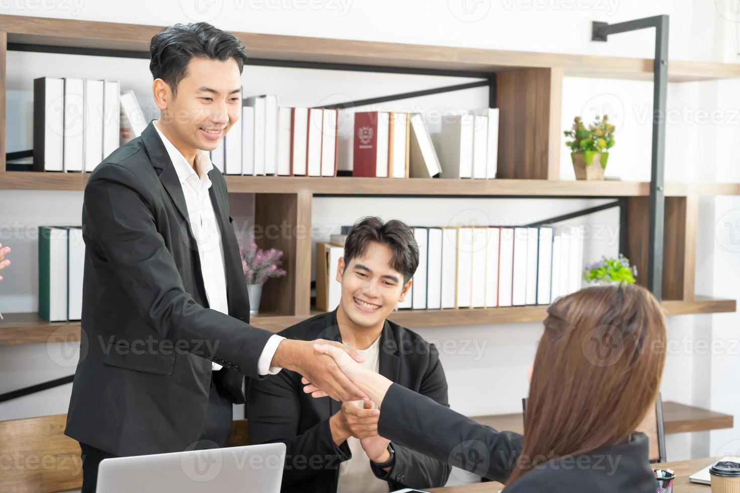 Welkom naar onze team. jong modern mannen en vrouw in slim gewoontjes slijtage beven handen. drie glimlachen mensen uit het bedrijfsleven beven handen samen. foto