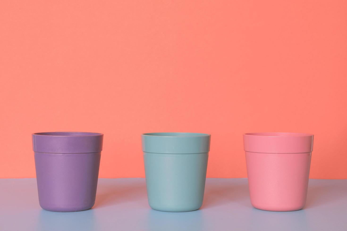 drie kleur plastic kop Aan pastel kleuren achtergrond. foto