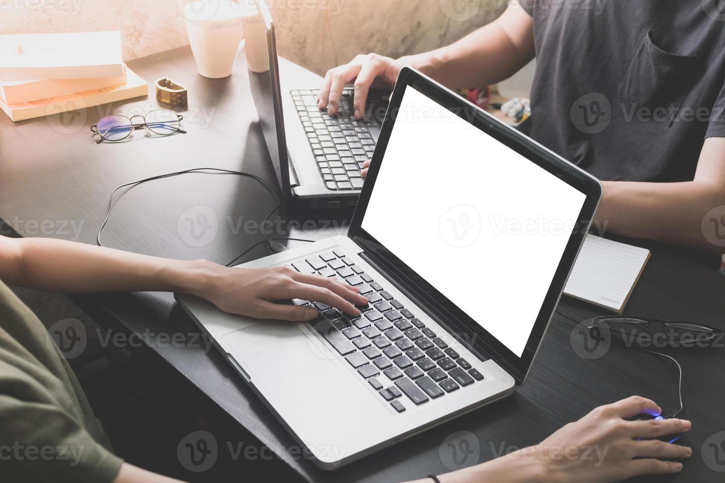 collega's werken Aan de dezelfde bureau, ze zijn gebruik makend van een laptop met blanco scherm, begin omhoog bedrijf concept foto