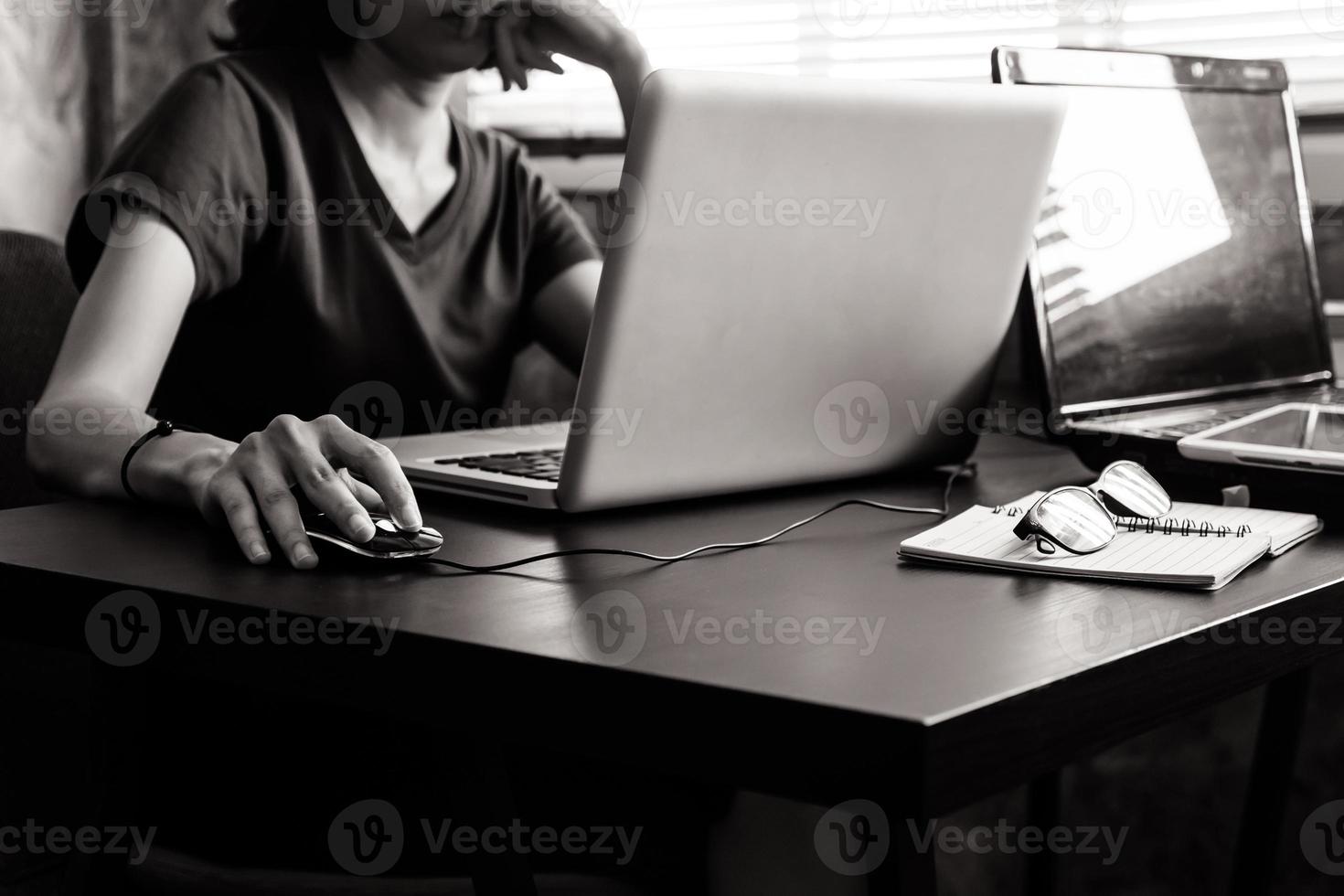 gewoontjes jong vrouw gebruik makend van een laptop Aan de bureau. zwart en wit toon foto