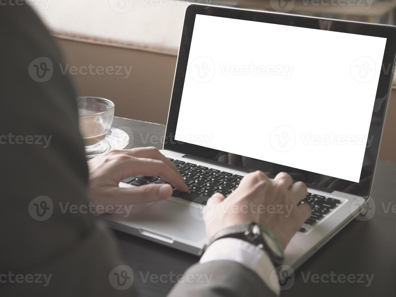 dichtbij omhoog van zakenman gebruik makend van een laptop met wit scherm Aan de bureau. foto