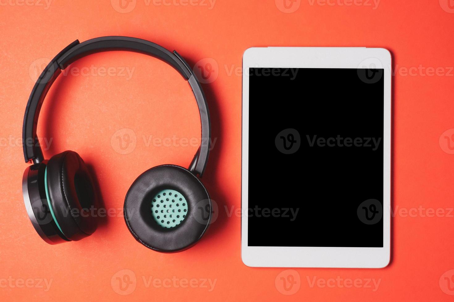 modern hoofdtelefoons met tablet pc Aan een oranje achtergrond. foto