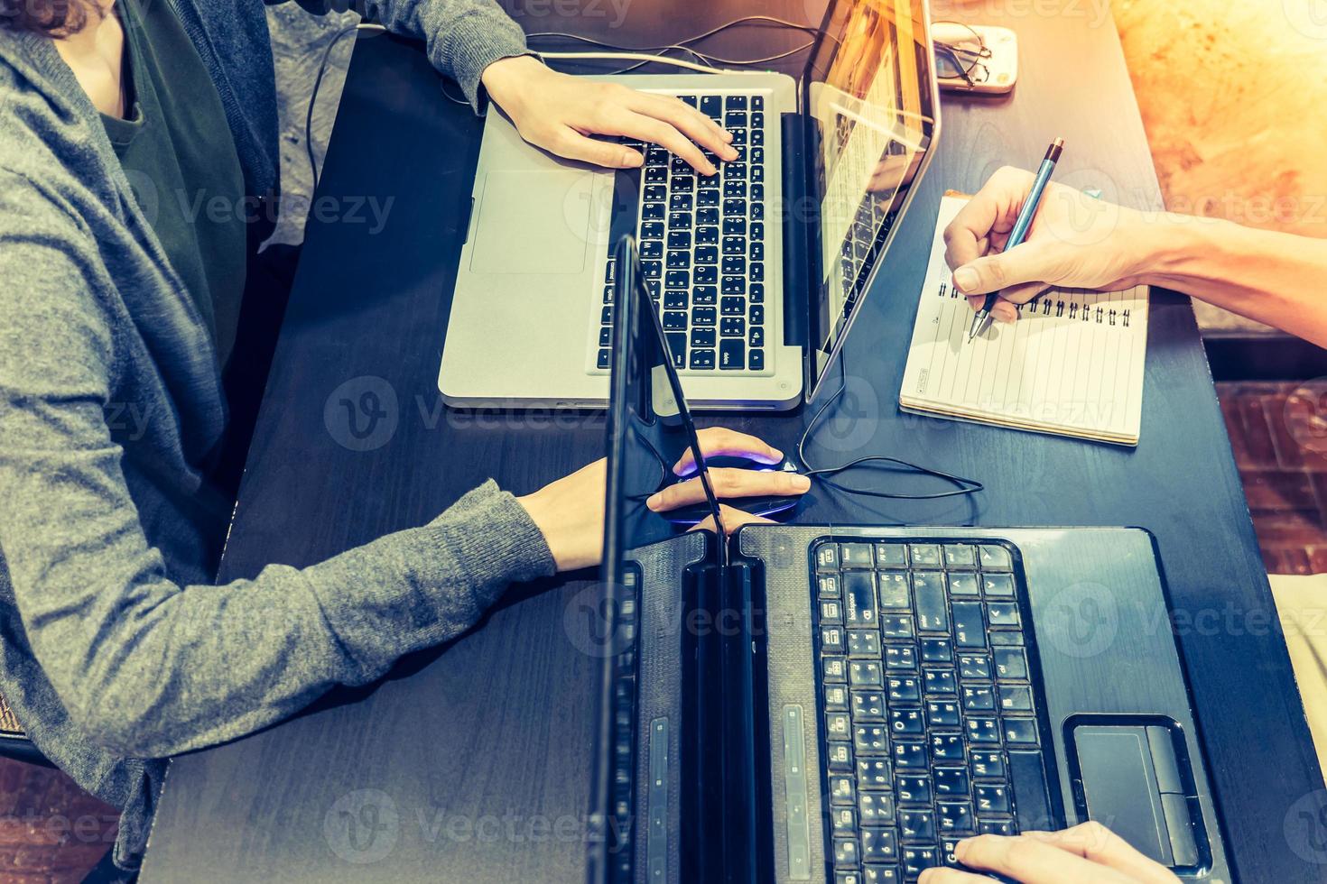 collega's werken Aan de dezelfde bureau, ze zijn gebruik makend van een laptop, begin omhoog bedrijf concept, wijnoogst toon foto