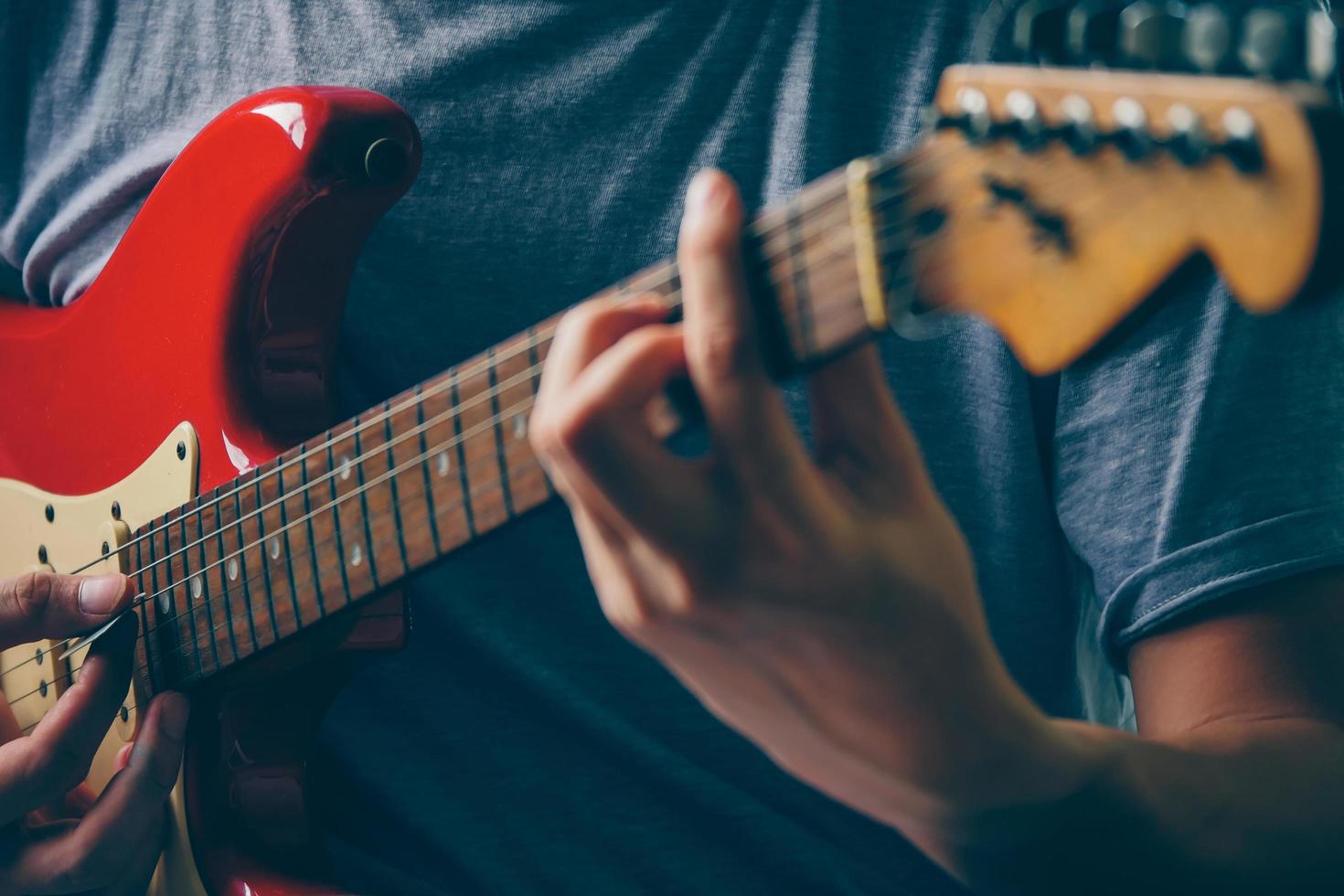 dichtbij omhoog van mannetje handen spelen elektrisch gitaar. selectief focus foto