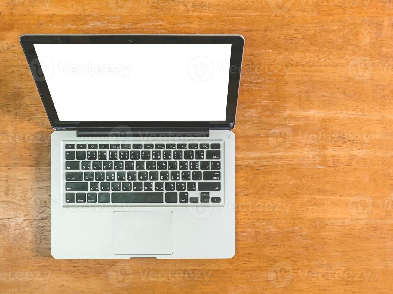 top visie van laptop met blanco scherm Aan houten tafel foto