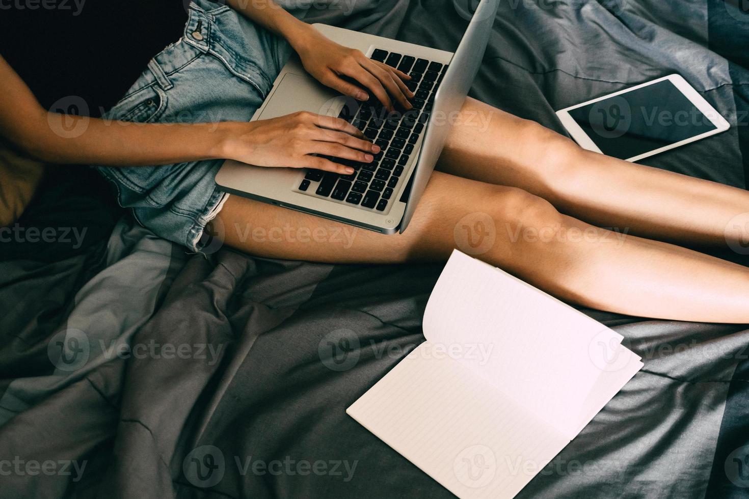 dichtbij omhoog van jong vrouw gebruik makend van laptop in bed, films graan filter. foto