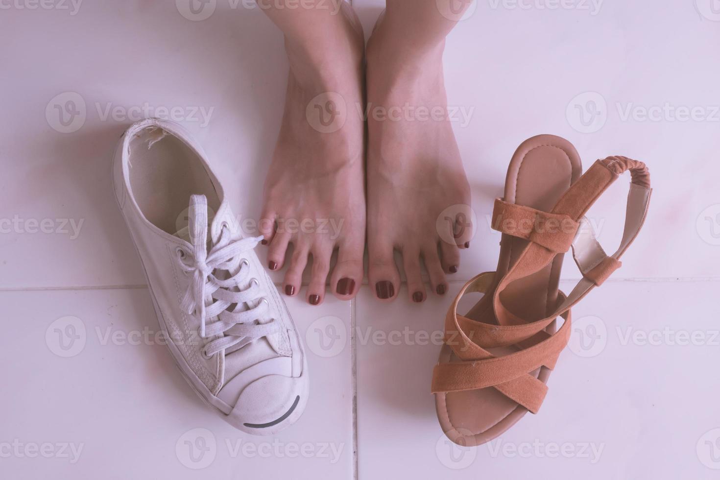 dichtbij omhoog van vrouw voeten met hoog hakken schoenen en gewoontjes sport- schoenen. foto